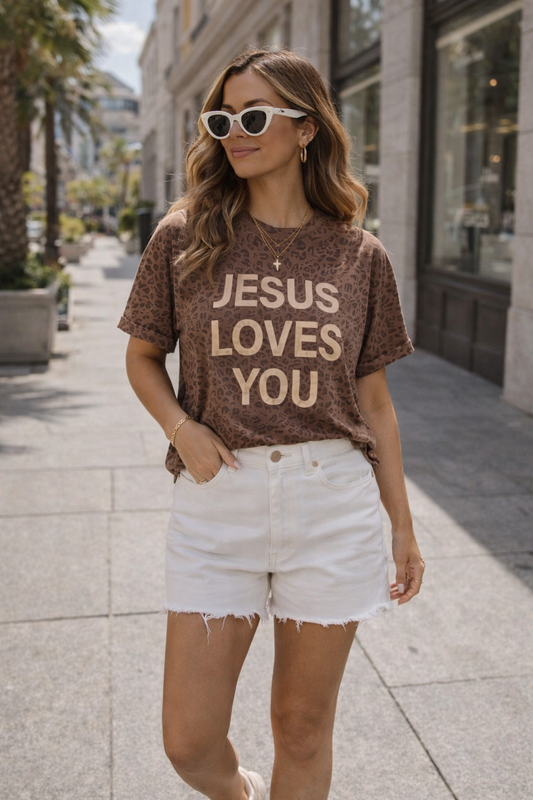 Woman wearing a 'Jesus Loves You' t-shirt on a city street.