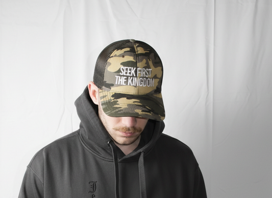 Person wearing a black hoodie and camouflage cap with text on a white background