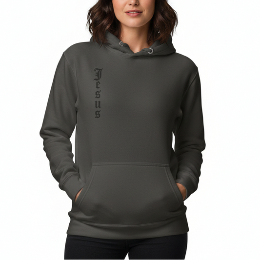Woman wearing a dark gray hoodie with 'Jesus' printed on it against a white background