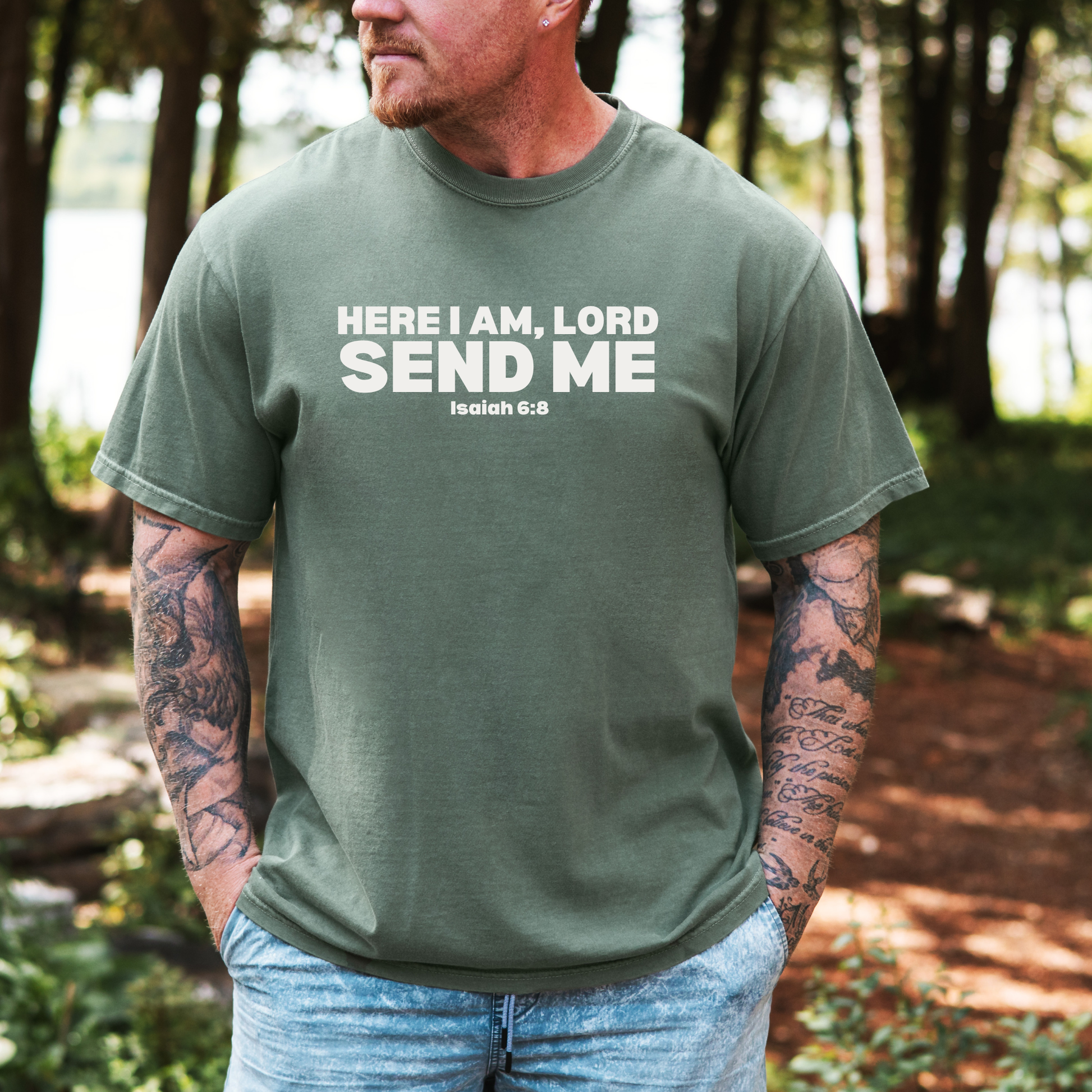 Man wearing a green t-shirt with text in a forest setting
